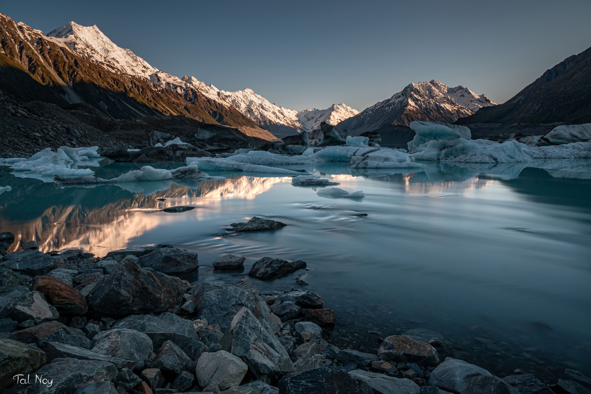 Icebergs and mountain reflections in a still lake at sunrise, Mount Cook National Park, New Zealand